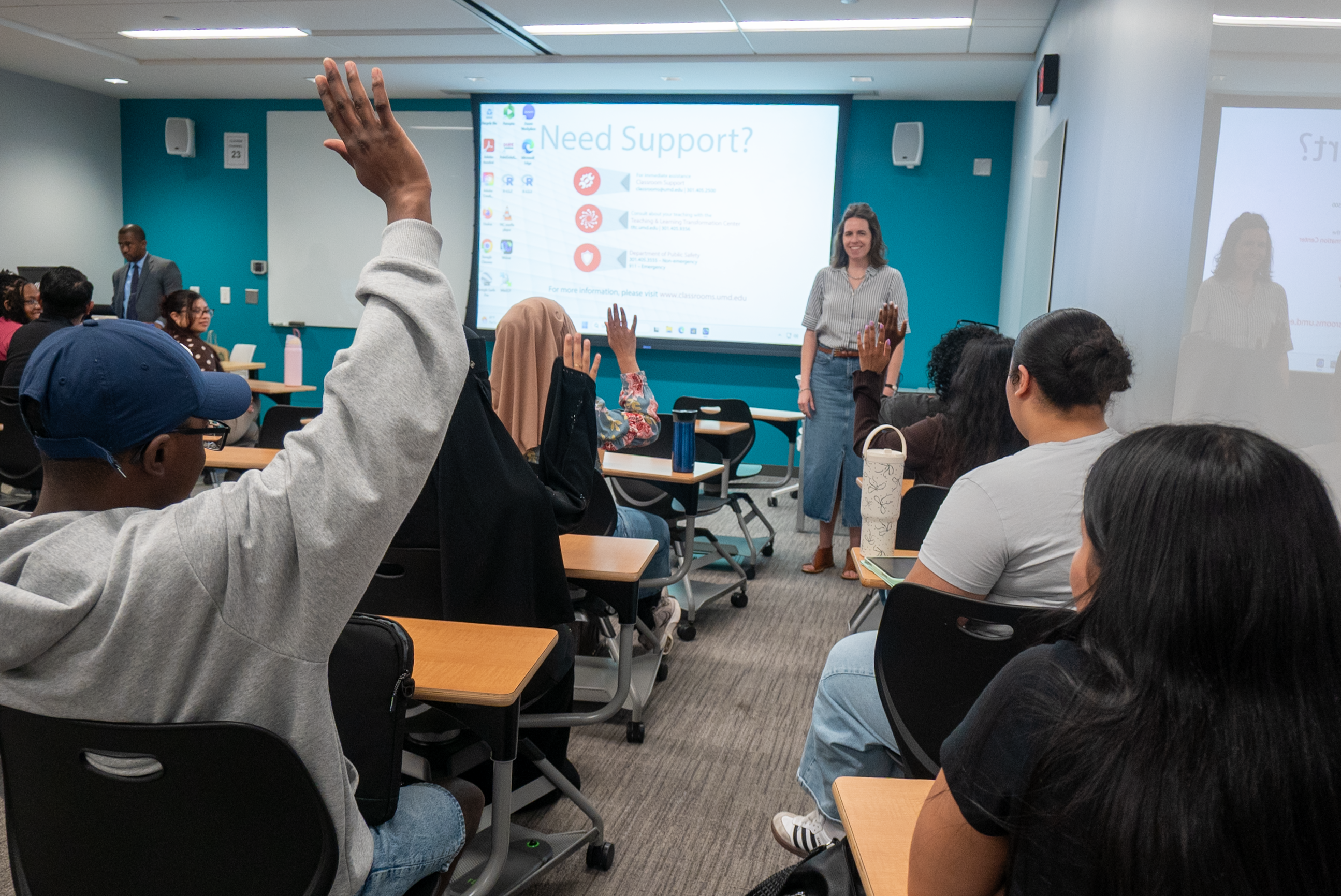 man with hand raised in front of a whiteboard